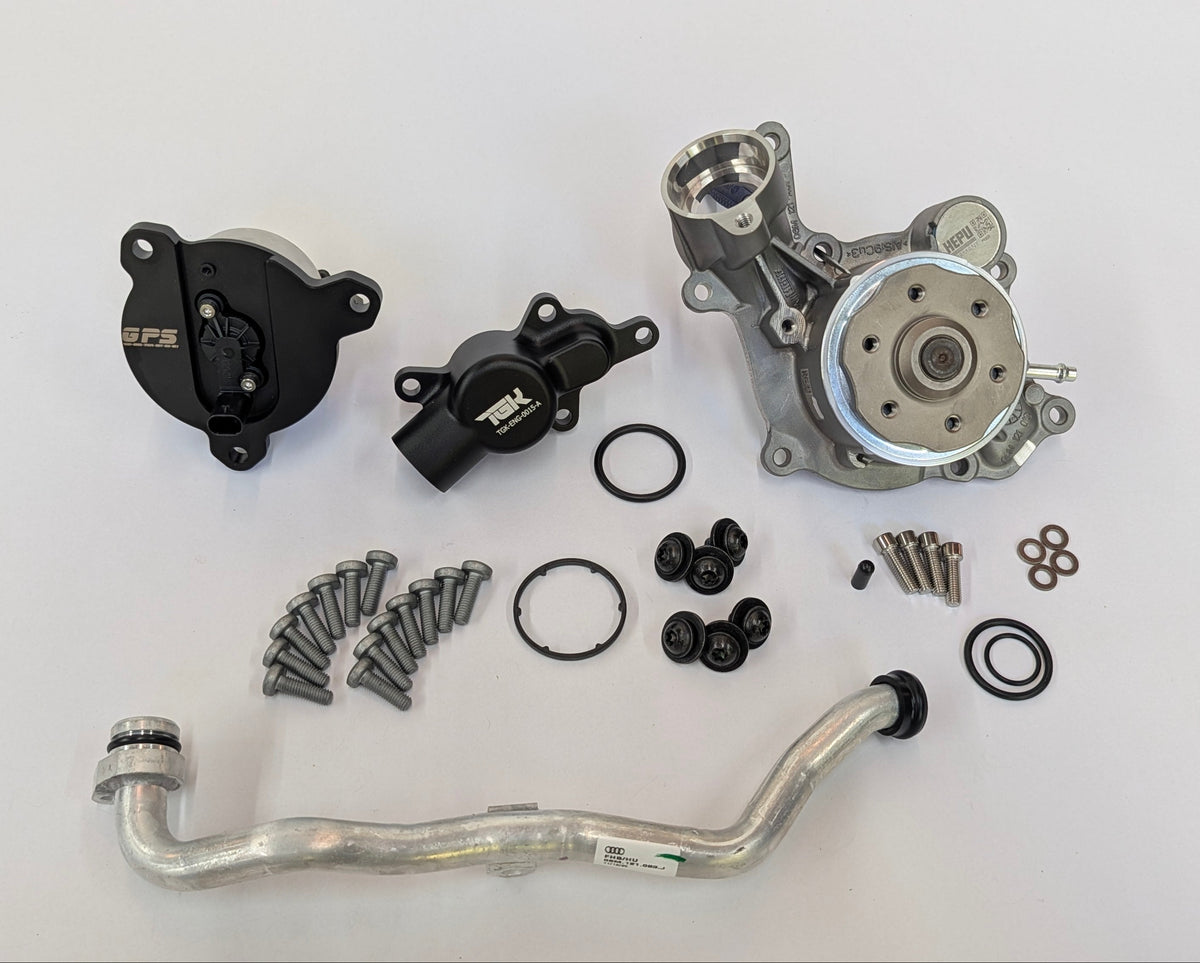A water pump kit laid out on a white background, including a silver water pump, black pulley and thermostat housings by German performance solutions, an aluminum radiator hose, gaskets, O-rings, and mounting hardware.